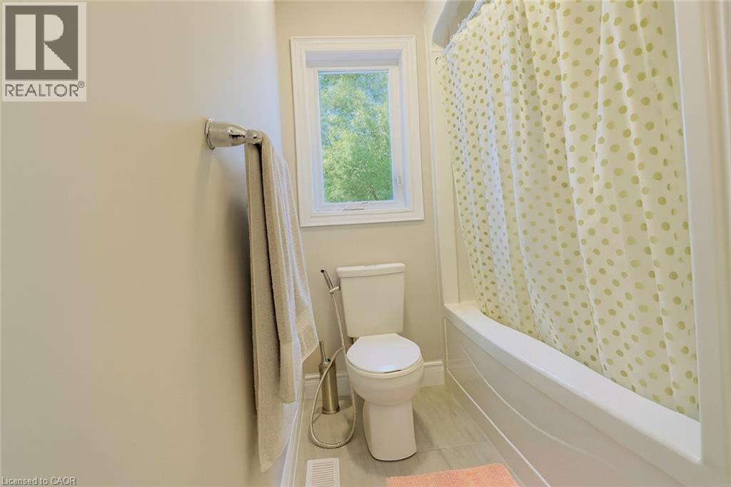 Bathroom featuring shower / bathtub combination with curtain and toilet - 195 Water Street, St. Jacobs, ON - Indoor Photo Showing Bathroom