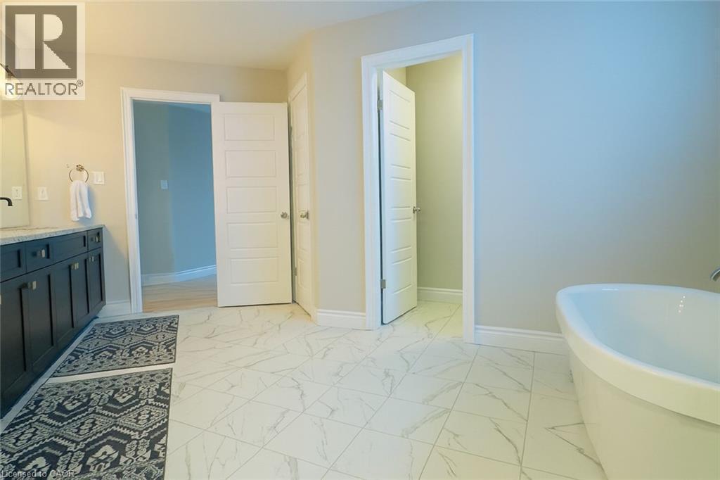 Bathroom with light marble finish floors, vanity, and a freestanding tub - 195 Water Street, St. Jacobs, ON - Indoor Photo Showing Bathroom