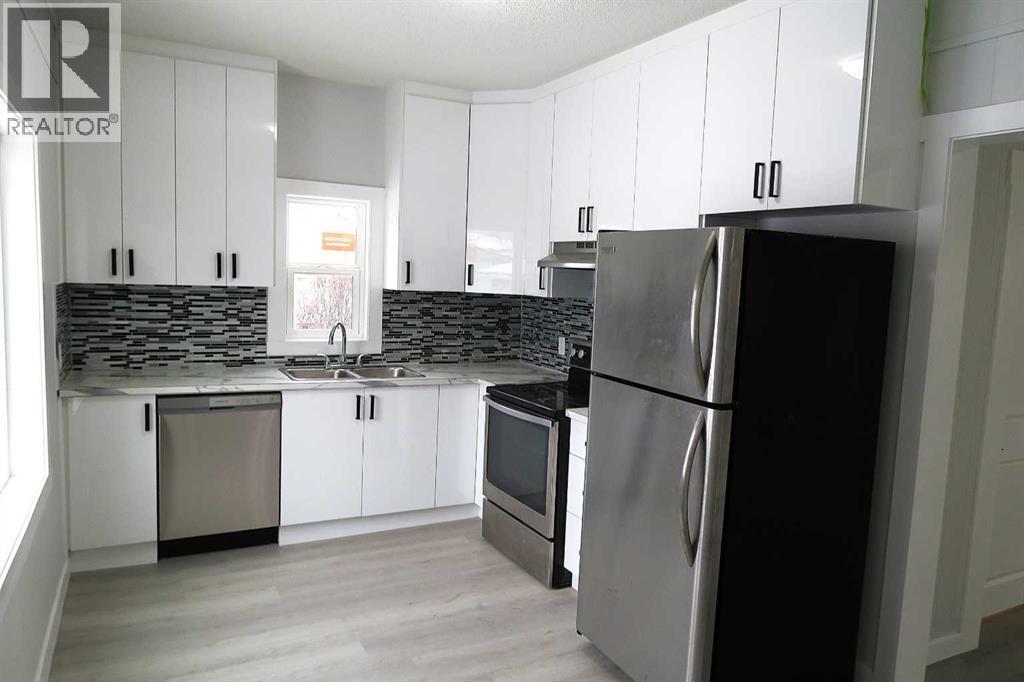 STUNNING NEW FLOOR to CEILING KITCHEN CABINETS accented with STAINLESS STEEL APPLIANCES - 111 6 Avenue Se, Three Hills, AB