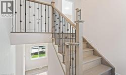 Stairway with wood finished floors and baseboards -