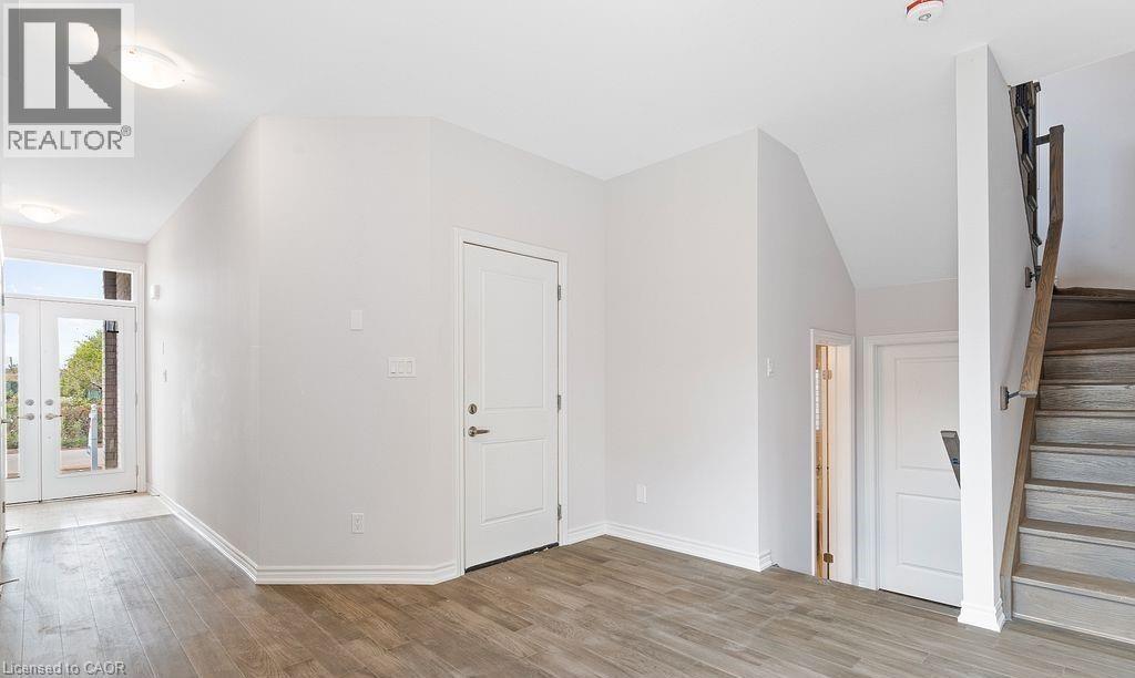 Foyer entrance with french doors, stairs, and wood finished floors - 103 Mclaughlin Street, Welland, ON - Indoor Photo Showing Other Room