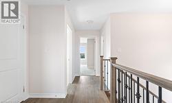 Hall with dark wood-style flooring and an upstairs landing -
