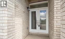 Doorway to property featuring french doors and brick siding -