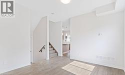 Spare room featuring light wood-type flooring and stairs -