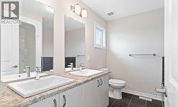 Full bathroom with dark tile patterned flooring and double vanity -