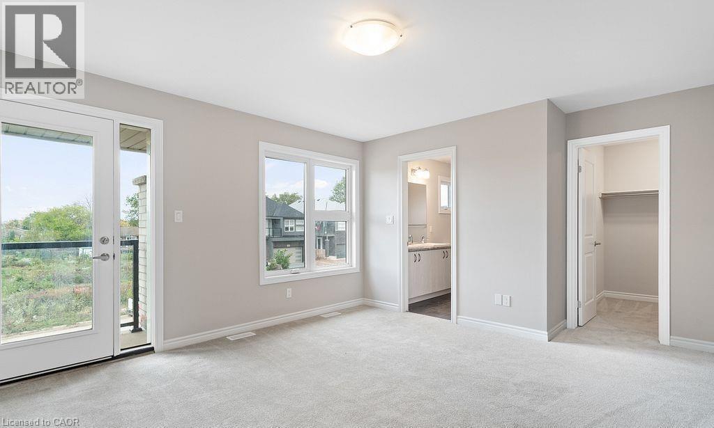 Unfurnished bedroom with a spacious closet, light carpet, access to exterior, and ensuite bath - 103 Mclaughlin Street, Welland, ON - Indoor Photo Showing Other Room