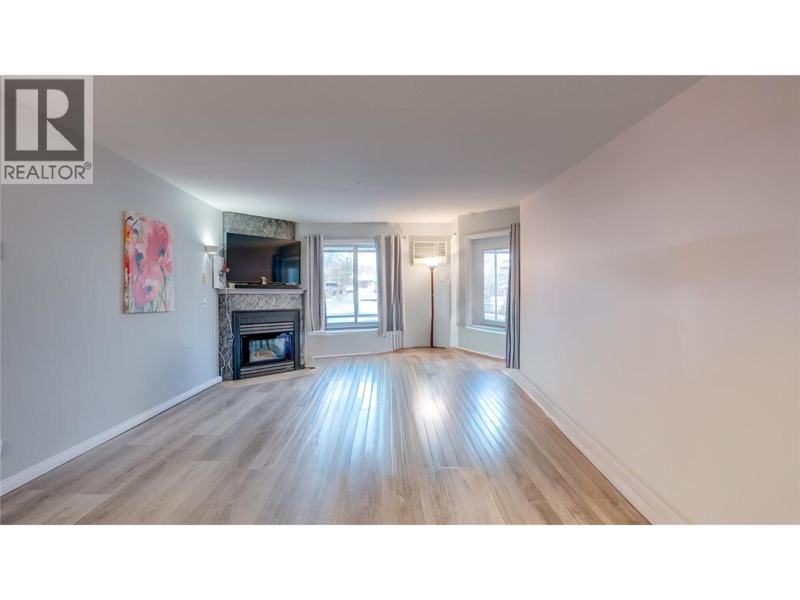 Livingroom with corner gas fireplace. - 3705 30 Avenue Unit# 104, Vernon, BC - Indoor Photo Showing Living Room With Fireplace
