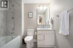 Full bath featuring vanity and a combined bath / shower with marble appearance -