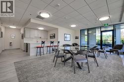 Dining area featuring a wall of windows, a paneled ceiling, and light wood finished floors -