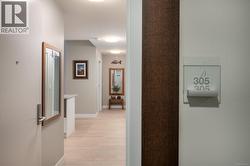 Corridor with baseboards and light wood-type flooring -
