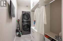 Laundry area featuring stacked washer / drying machine and baseboards -