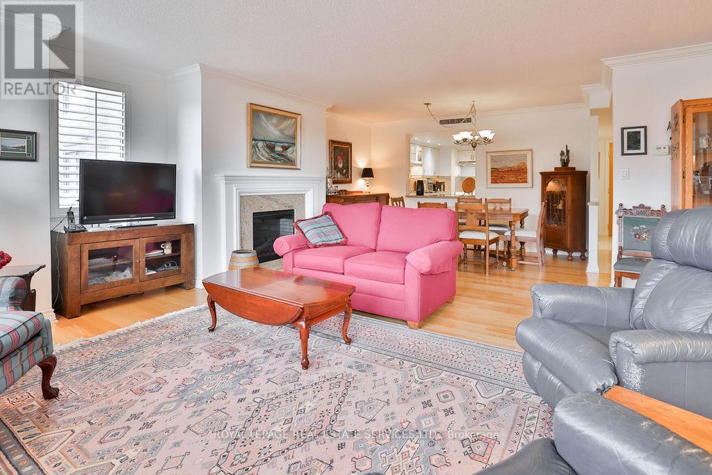 708 - 100 Lakeshore Road E, Oakville, ON - Indoor Photo Showing Living Room With Fireplace