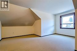 Additional living space featuring lofted ceiling and carpet floors -
