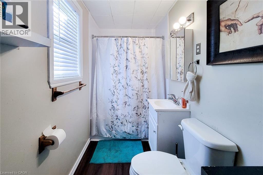 Full bath with vanity, dark wood finished floors, and shower / bath combo - 558 Barnaby Street, Hamilton, ON - Indoor Photo Showing Bathroom