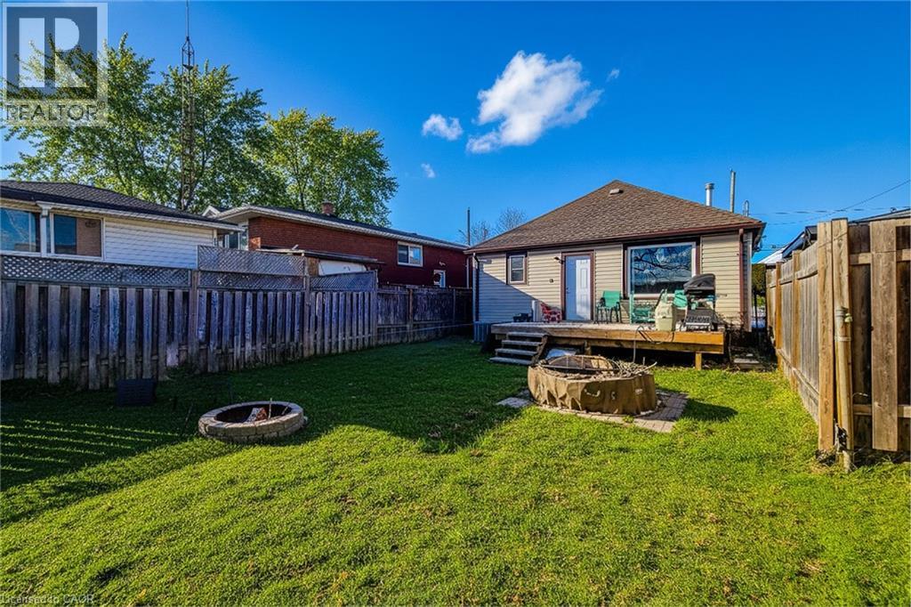 Rear view of property featuring a fire pit, a fenced backyard, and a deck - 558 Barnaby Street, Hamilton, ON - Outdoor With Deck Patio Veranda