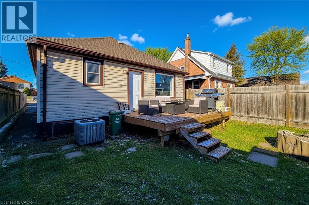 Back of property with a wooden deck, a fenced backyard, and roof with shingles - 558 Barnaby Street, Hamilton, ON - Outdoor With Deck Patio Veranda