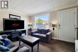 Carpeted living room featuring ornamental molding -