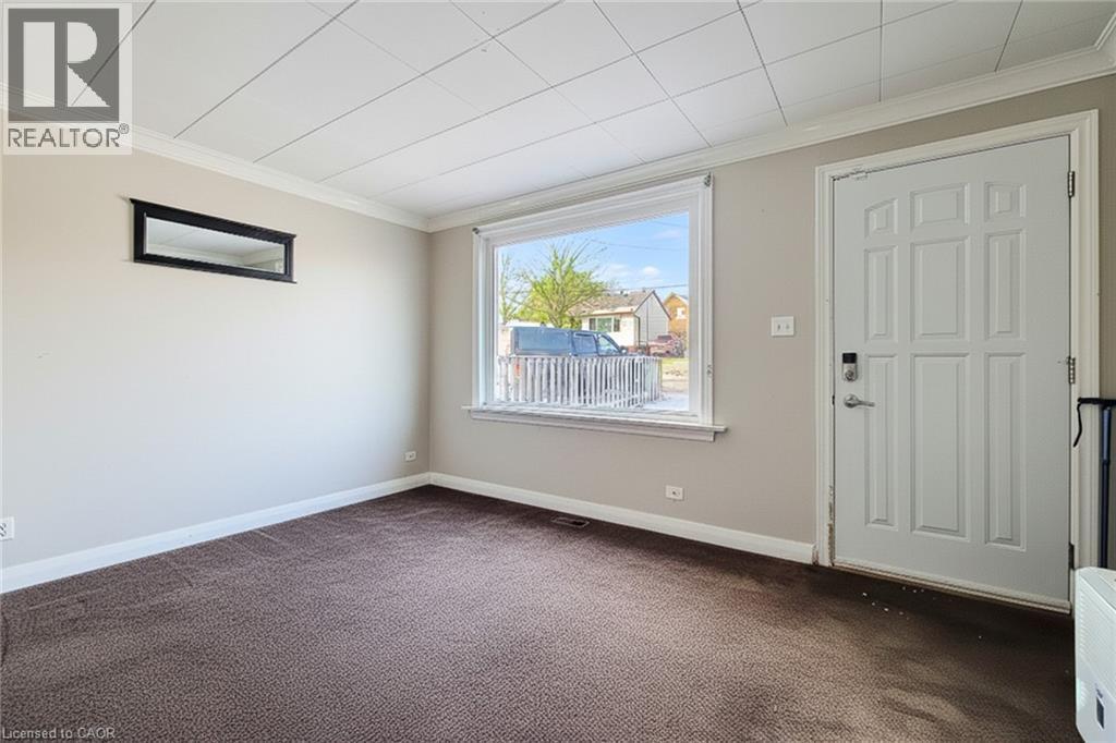 Entryway with crown molding and dark colored carpet - 558 Barnaby Street, Hamilton, ON - Indoor Photo Showing Other Room