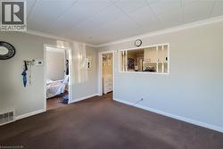 Carpeted spare room featuring crown molding and baseboards -