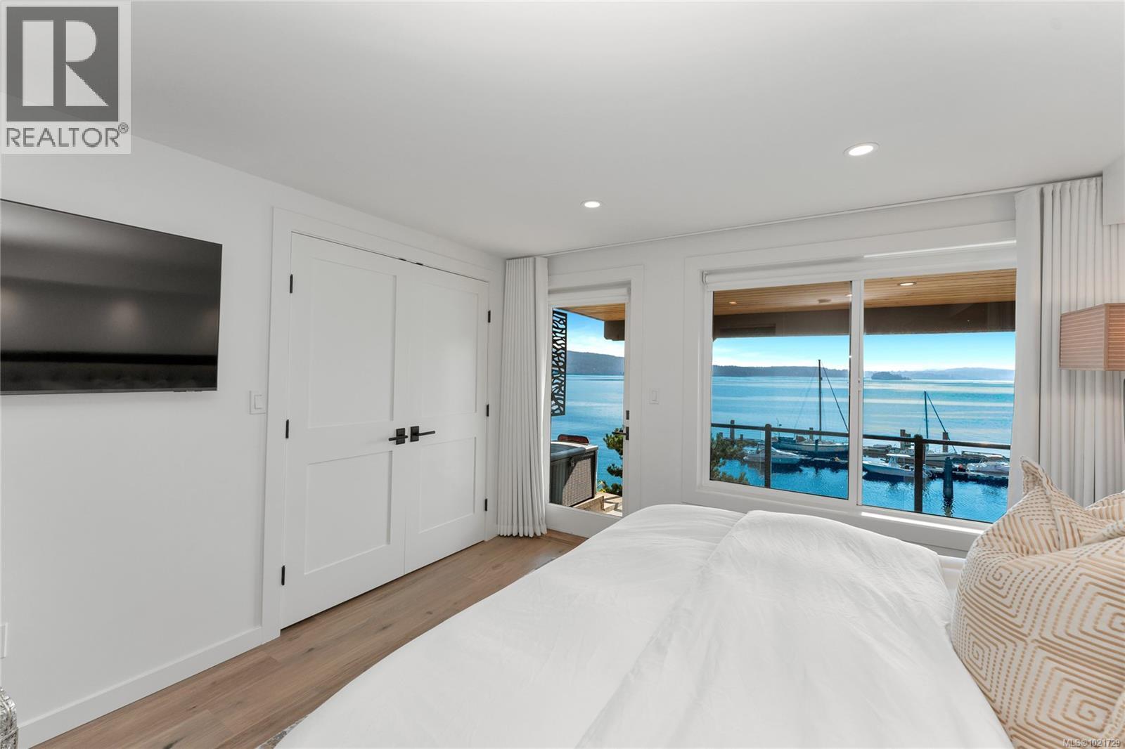 Second bedroom includes access to lower, covered deck - 4 1723 Sandy Beach Rd, Mill Bay, BC - Indoor Photo Showing Bedroom