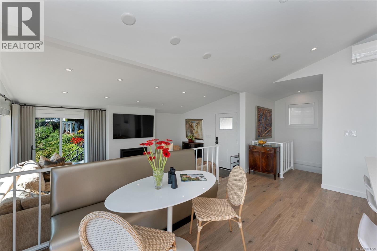 Dining area featuring hardwood floors, lofted ceiling and heat pump - 4 1723 Sandy Beach Rd, Mill Bay, BC - Indoor Photo Showing Dining Room