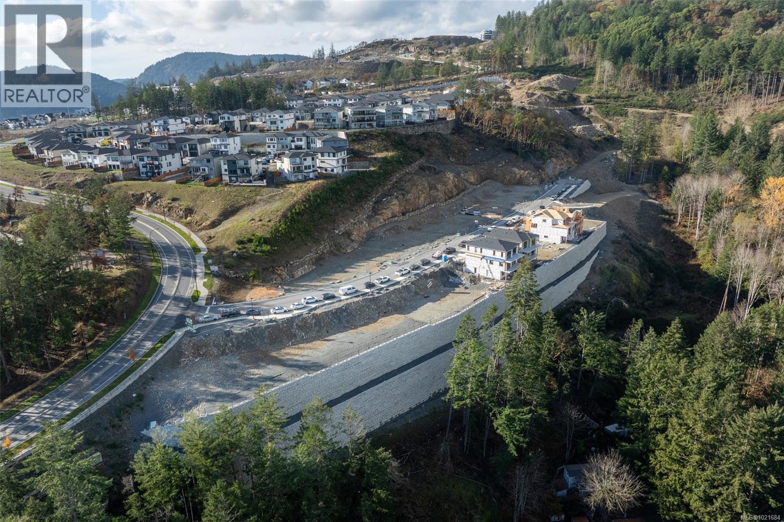 Aerial view of property and surrounding area featuring a mountain backdrop and nearby suburban area - 1204 Cedarbrook Way, Langford, BC
