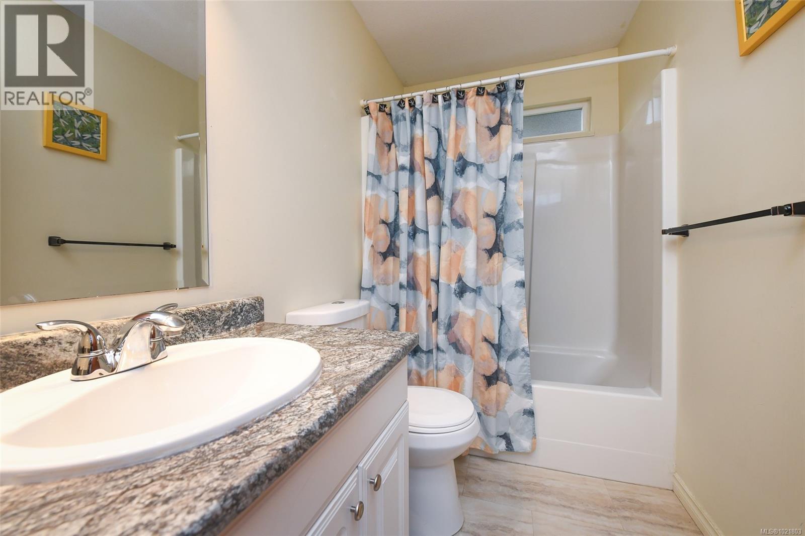 Full bath with vanity, shower / tub combo with curtain, and light wood-style floors - 31 1535 Dingwall Rd, Courtenay, BC - Indoor Photo Showing Bathroom