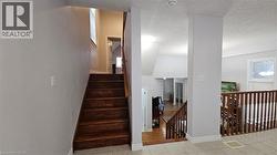 Stairway with a textured ceiling and tile patterned flooring -