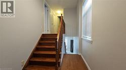 Stairs with baseboards and wood finished floors -