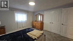 Bedroom featuring a textured ceiling, carpet flooring, and a closet -