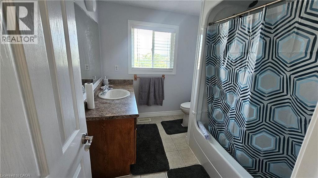 Full bath featuring vanity, light tile patterned floors, and shower / bath combination with curtain - 10 Doll Court Unit# Room 3, Kitchener, ON - Indoor Photo Showing Bathroom