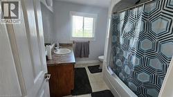Full bath featuring vanity, light tile patterned floors, and shower / bath combination with curtain -