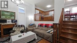 Living room featuring stairs, a fireplace, wood finished floors, and plenty of natural light -