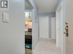 Hall featuring light colored carpet and baseboards -