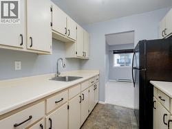 Kitchen with freestanding refrigerator, light countertops, and a baseboard radiator -