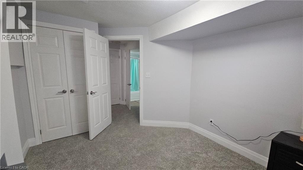 Unfurnished bedroom with a closet, light colored carpet, and a textured ceiling - 10 Doll Court Unit# Lower, Kitchener, ON - Indoor Photo Showing Other Room