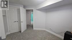 Unfurnished bedroom with a closet, light colored carpet, and a textured ceiling -