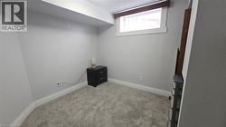 Bedroom featuring light carpet and baseboards -