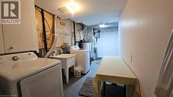 Washroom with finished concrete flooring, independent washer and dryer, and water heater -