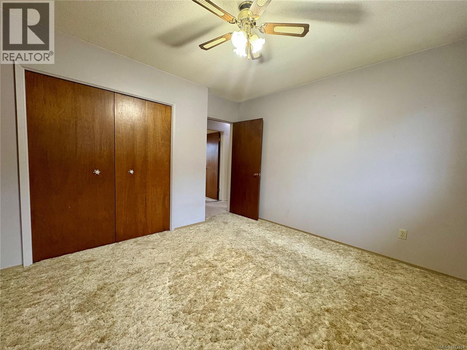 Unfurnished bedroom featuring a closet, ceiling fan, carpet, and a textured ceiling - 2738 14Th Ave, Port Alberni, BC - Indoor Photo Showing Other Room