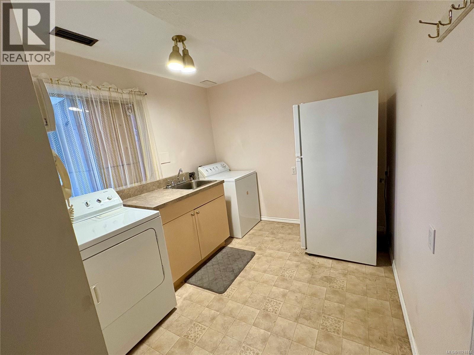 Laundry room with washer and dryer and cabinet space - 2738 14Th Ave, Port Alberni, BC - Indoor Photo Showing Laundry Room