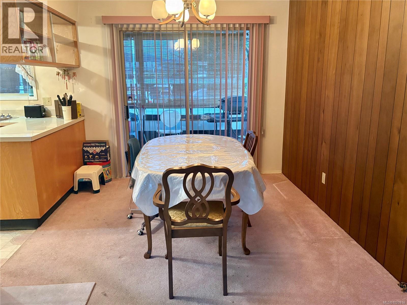 Dining room featuring wooden walls, a chandelier, and light carpet - 2738 14Th Ave, Port Alberni, BC - Indoor Photo Showing Dining Room