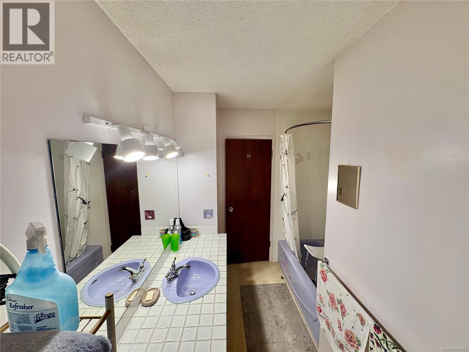 Bathroom featuring vanity, a textured ceiling, and shower / tub combo with curtain - 2738 14Th Ave, Port Alberni, BC - Indoor