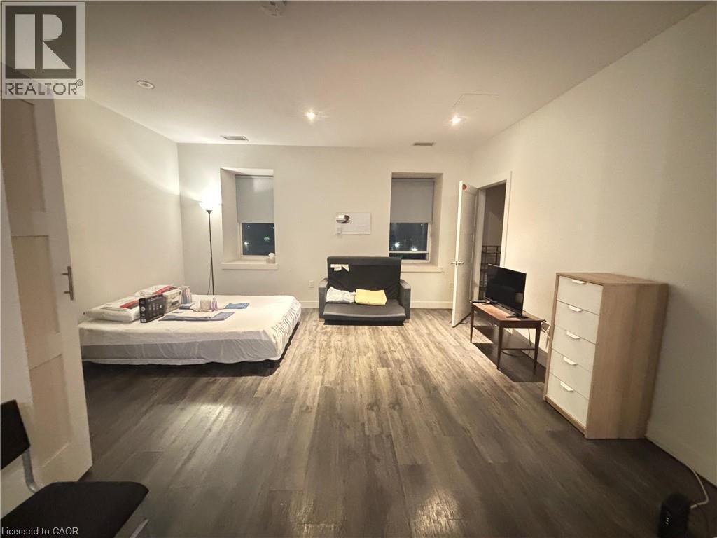 Bedroom with wood finished floors and recessed lighting - 25 Main Street Unit# 302, Cambridge, ON - Indoor