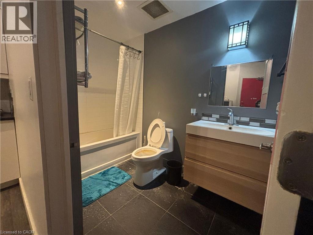 Full bathroom featuring vanity, shower / bath combo, and dark tile patterned flooring - 25 Main Street Unit# 302, Cambridge, ON - Indoor Photo Showing Bathroom