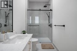 Bathroom featuring a shower stall and vanity -