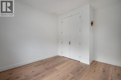 Unfurnished bedroom with wood finished floors and a closet -