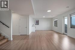 Unfurnished living room featuring light wood-type flooring and stairway -