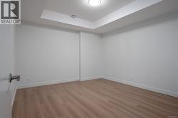 Empty room featuring light wood-style floors and a tray ceiling -