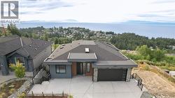 View of front of property with stone siding, a water view, a garage, and stucco siding -